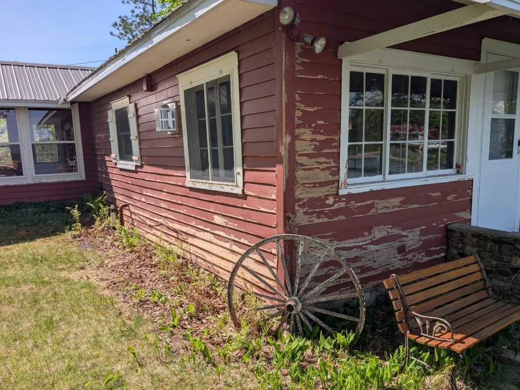 Before: Cabin exterior with peeling, faded paint before painting