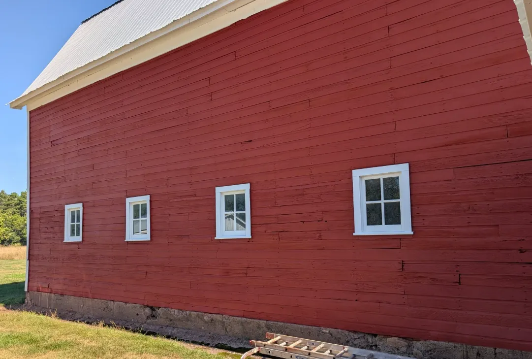 After: Red barn with fresh paint and white window trim
