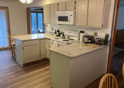 After: Kitchen with oak cabinets refinished in a soft white