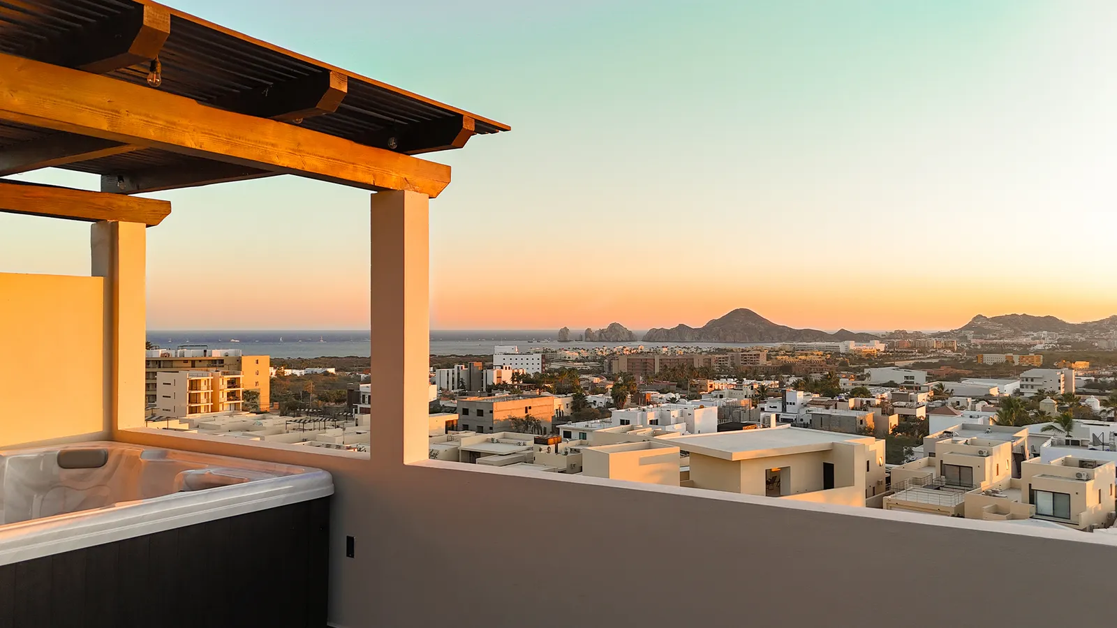 Rooftop privado del penthouse con jacuzzi al atardecer y el Arco al fondo