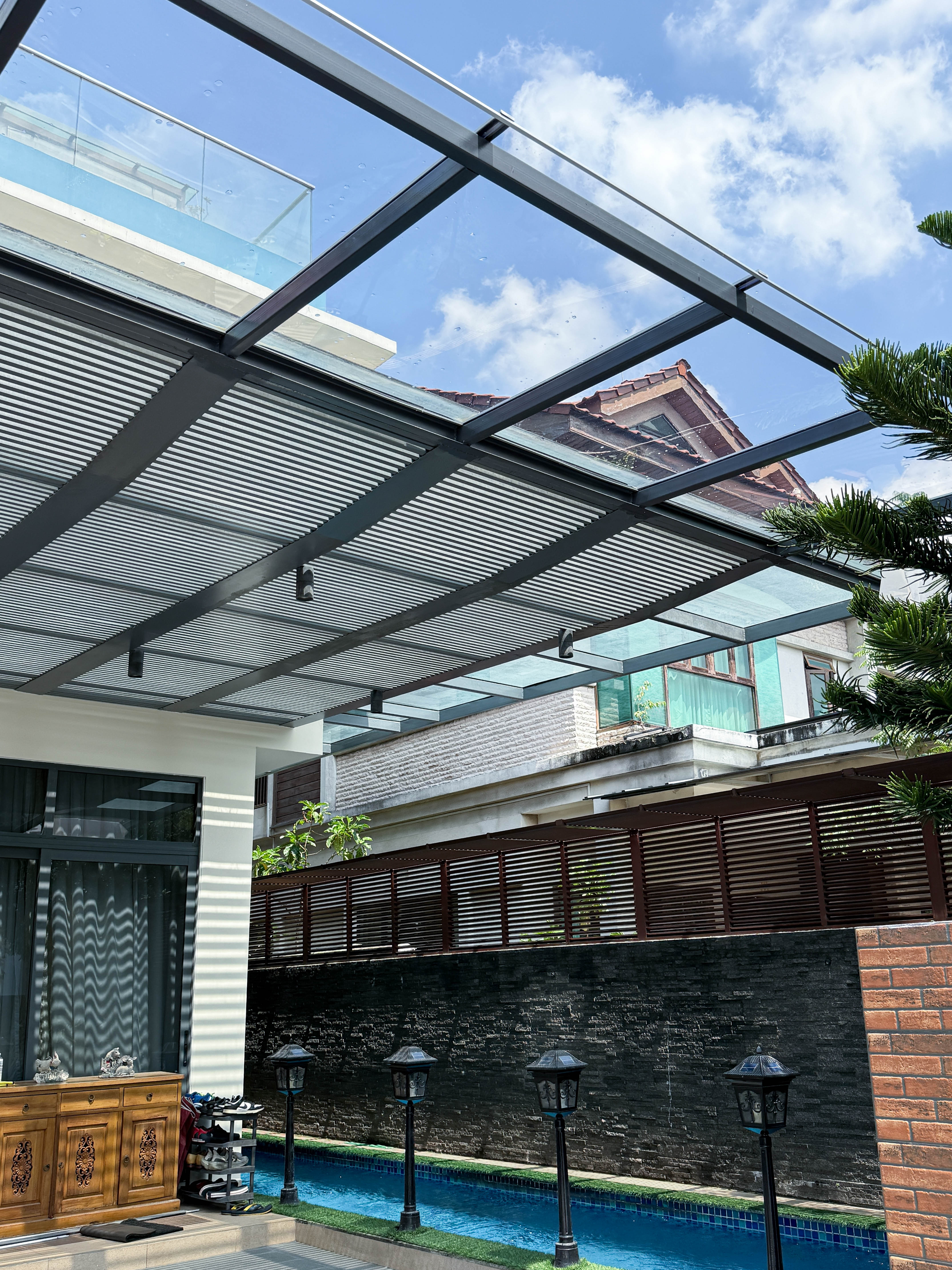 Glass and louvre roof beside a pool