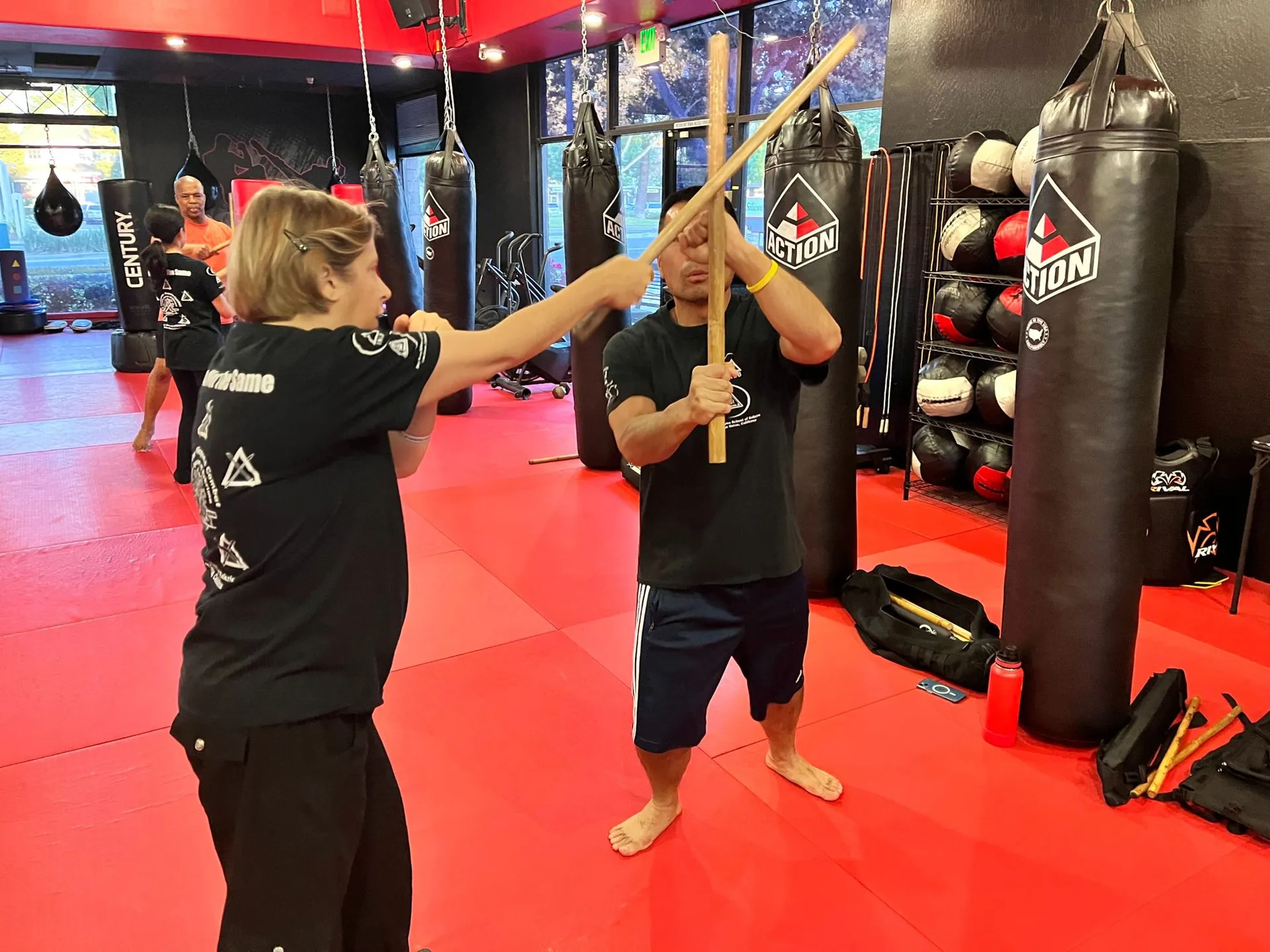 Partner stick training on red mats