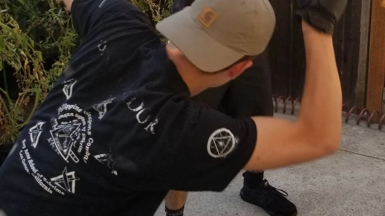 Inayan System of Eskrima practitioner in an Inayan shirt during training