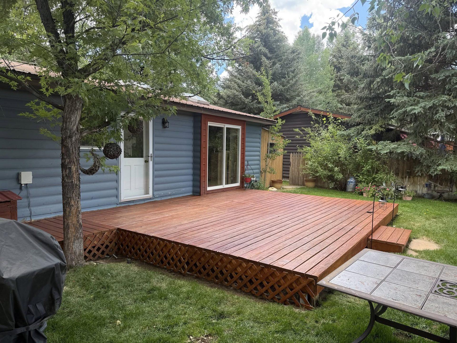 Wide view of a stained platform deck with matching lattice skirting and a small step