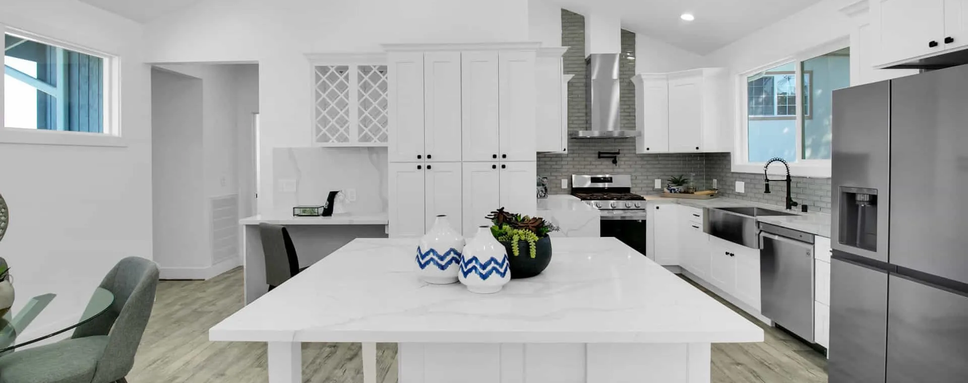 Open kitchen with a marble-look island and white shaker cabinets, completed by OpalProp