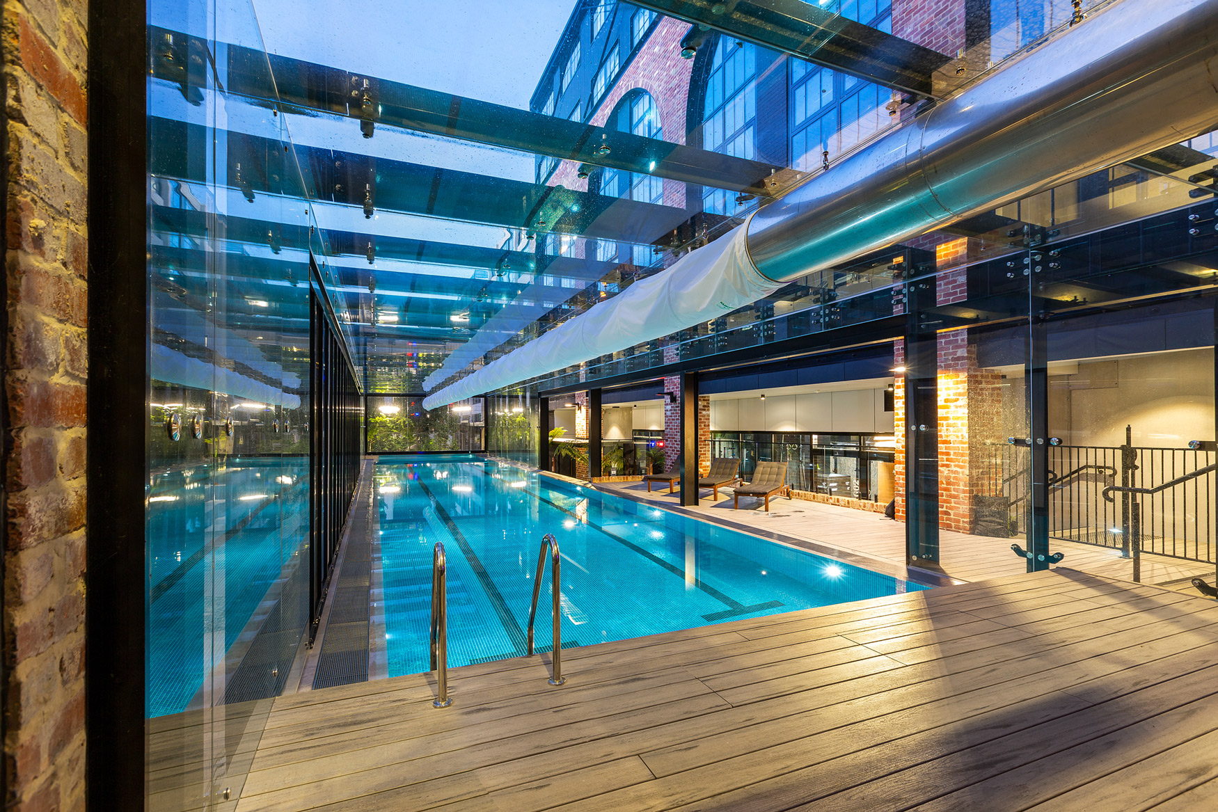 The 25m magnesium lap pool under its glass canopy at dusk