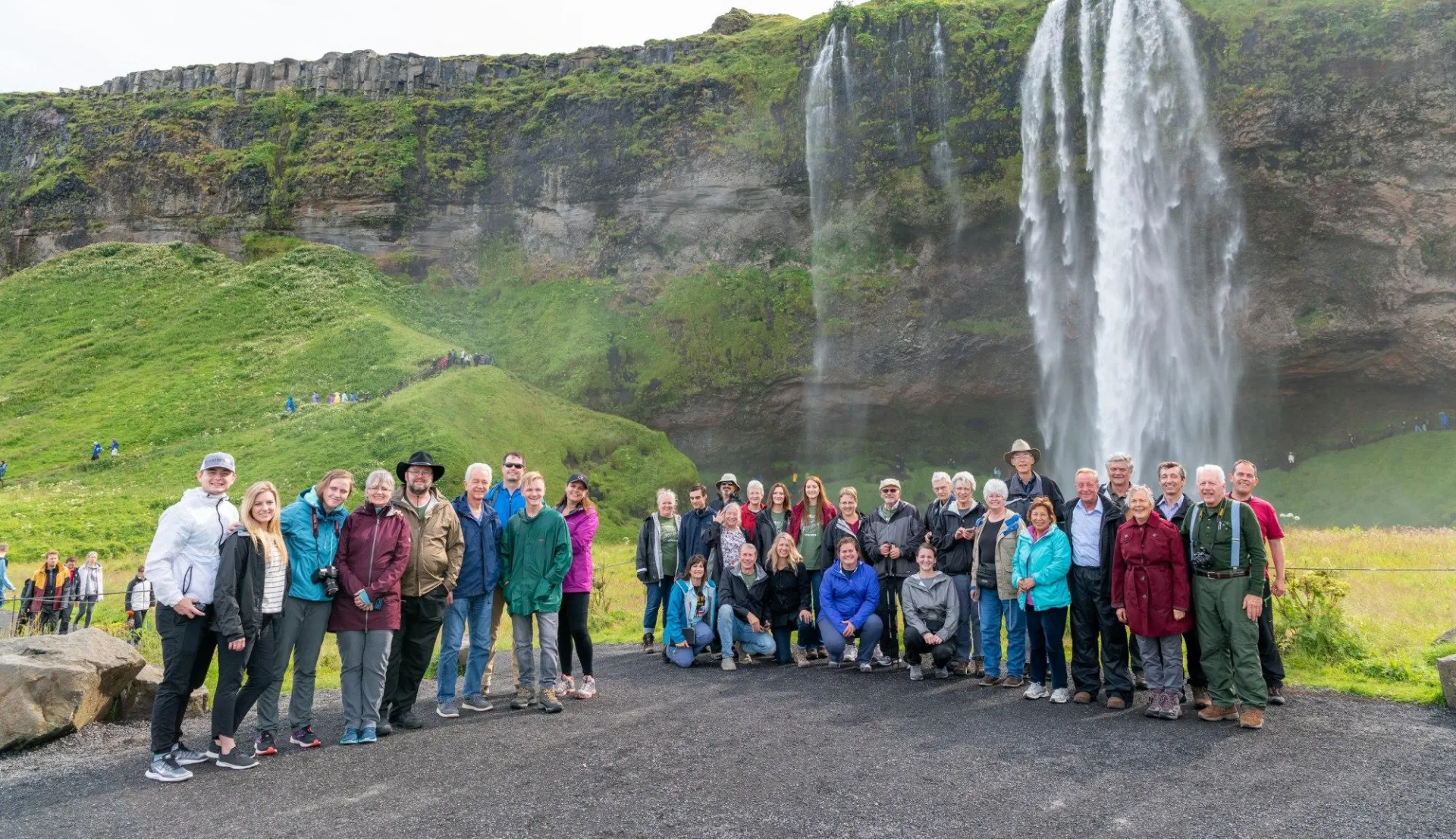 A TruthSeekers tour group in front of a waterfall