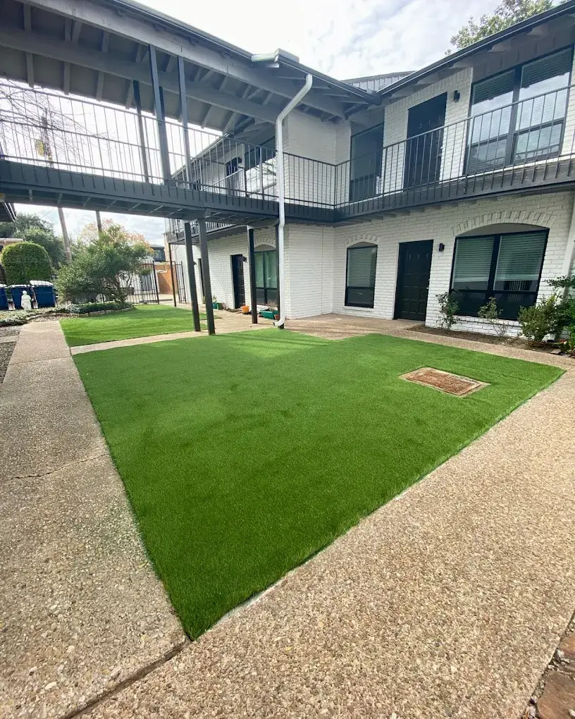 Synthetic turf lawn in a courtyard between concrete walkways