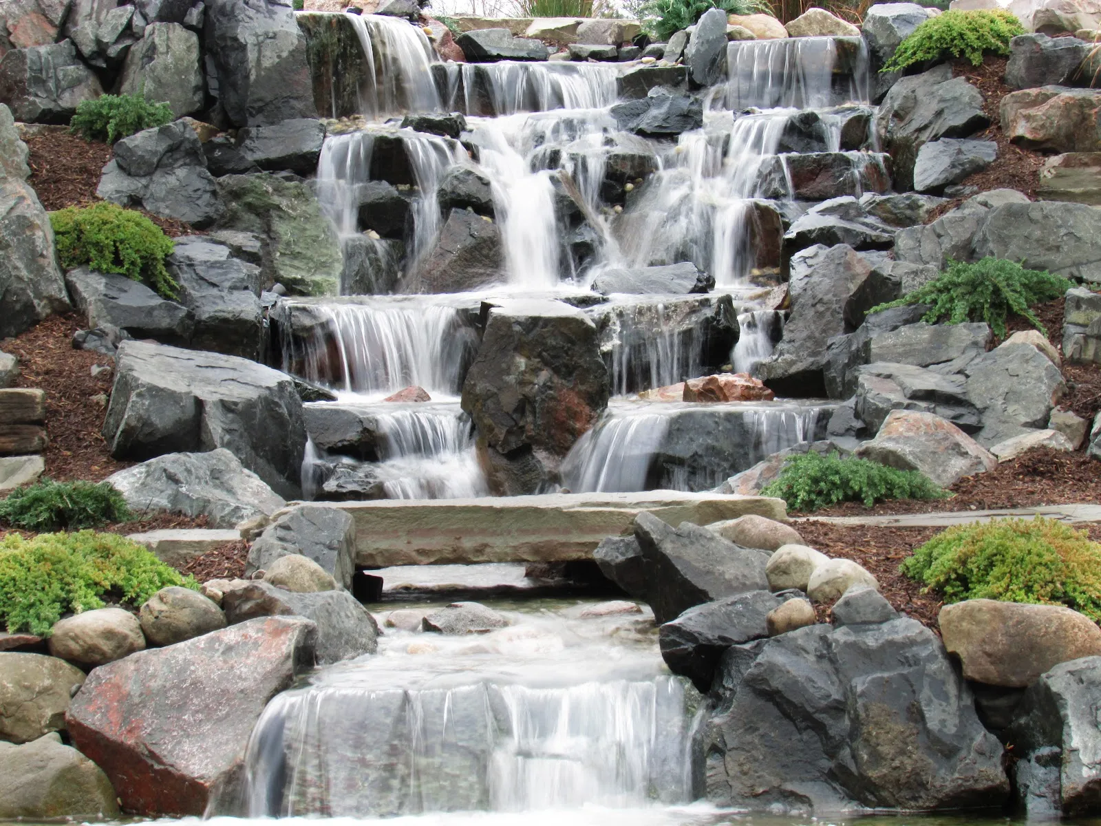 Multi-drop waterfall built by WaterScape, ATX spilling over layered stone