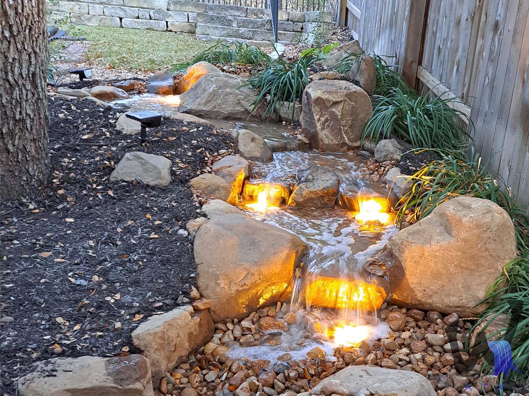 Water feature glowing with warm lighting after dark