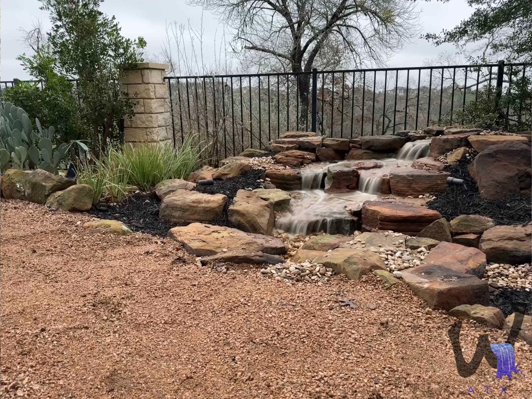 Pondless waterfall against a fence line