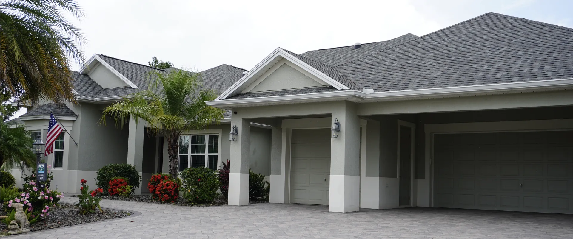 Florida home with a gray shingle roof and palm trees
