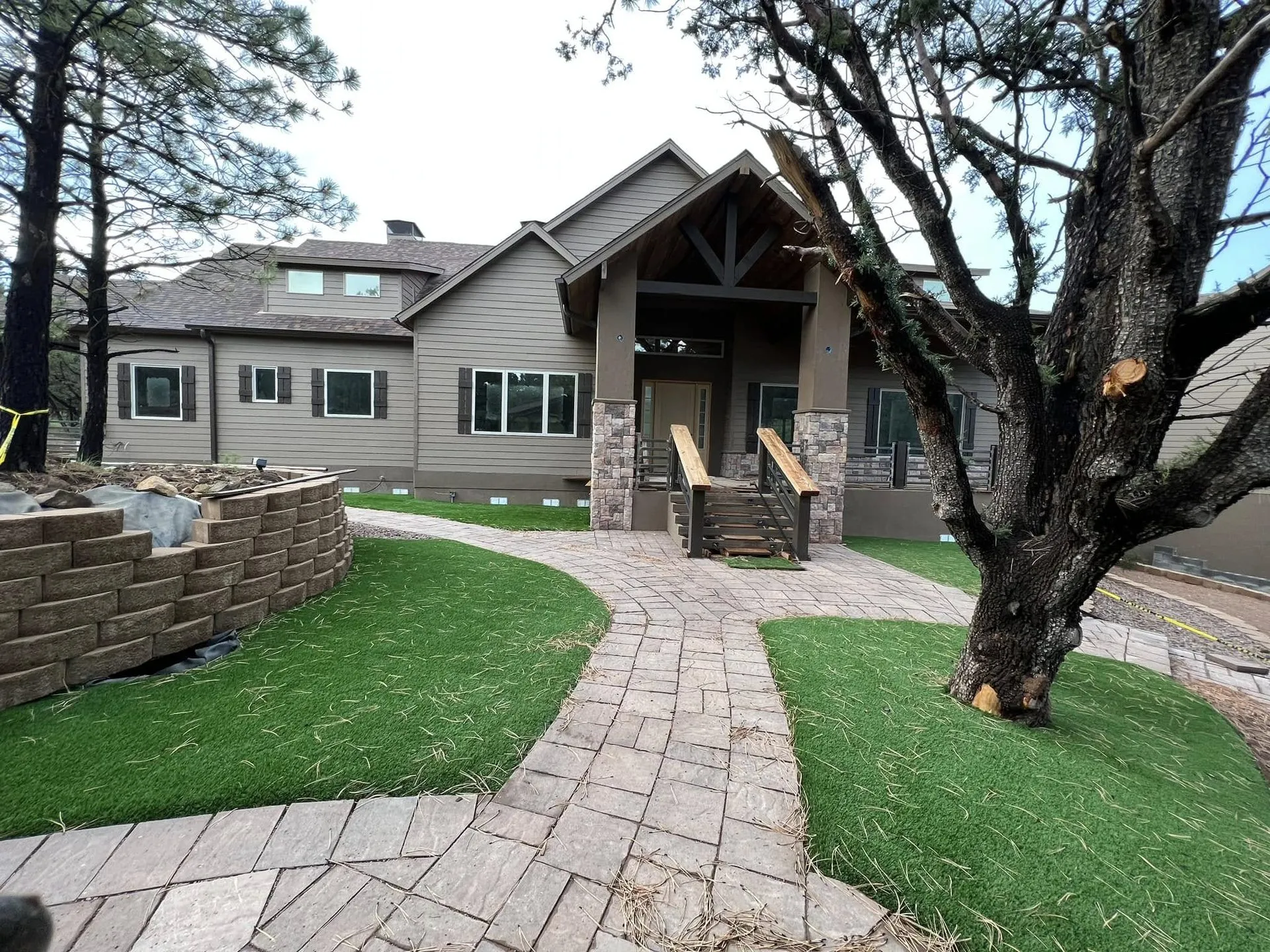 Craftsman-style home with stone columns and a paver walkway