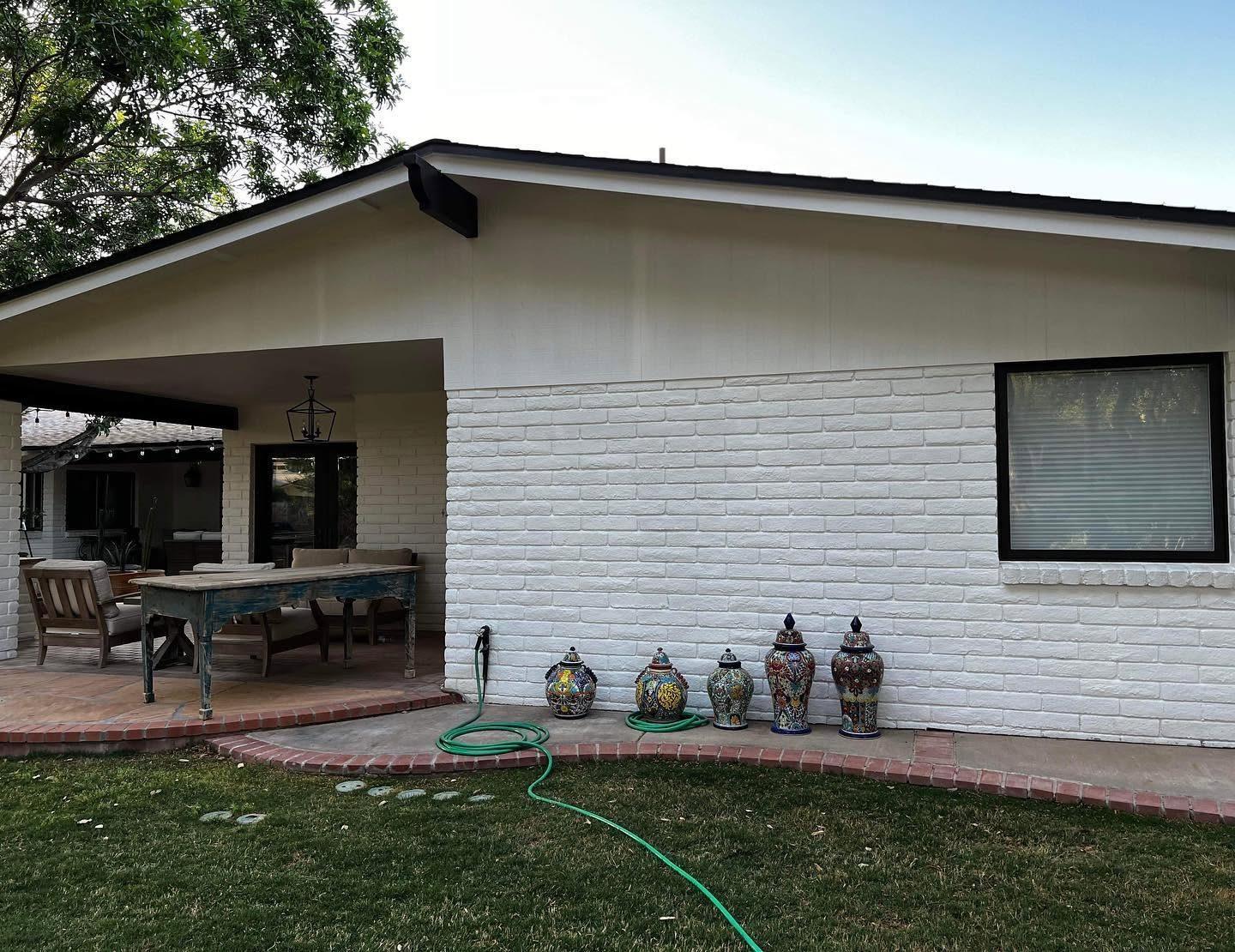 White painted brick home with a covered patio