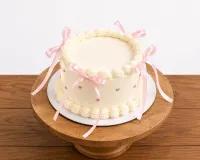 Butterscotch Celebration Cake with Pink Bows and Heart Accents 500gm – Image 1