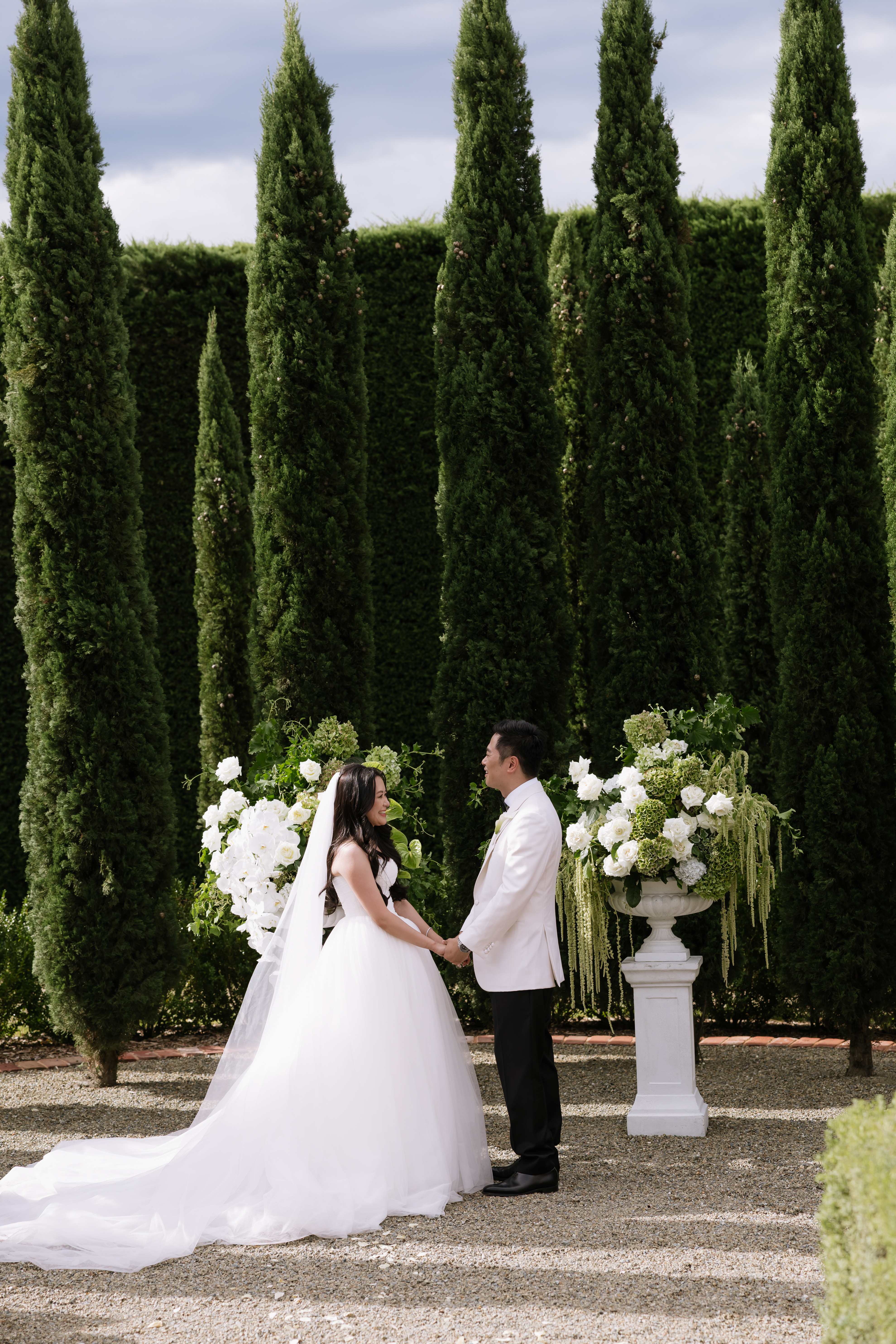 Ceremony framed by a row of cypress trees