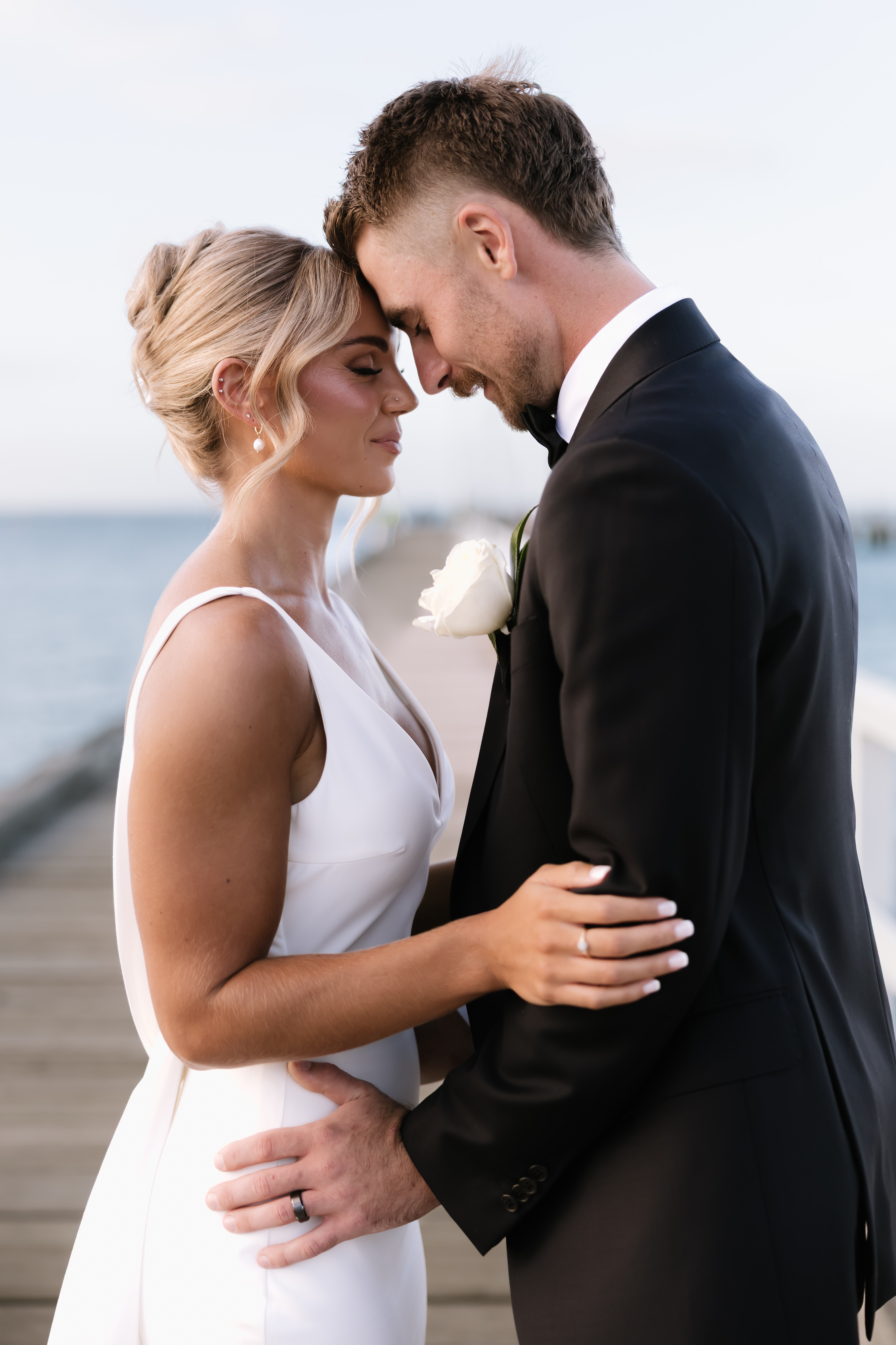 Couple with their foreheads together by the water