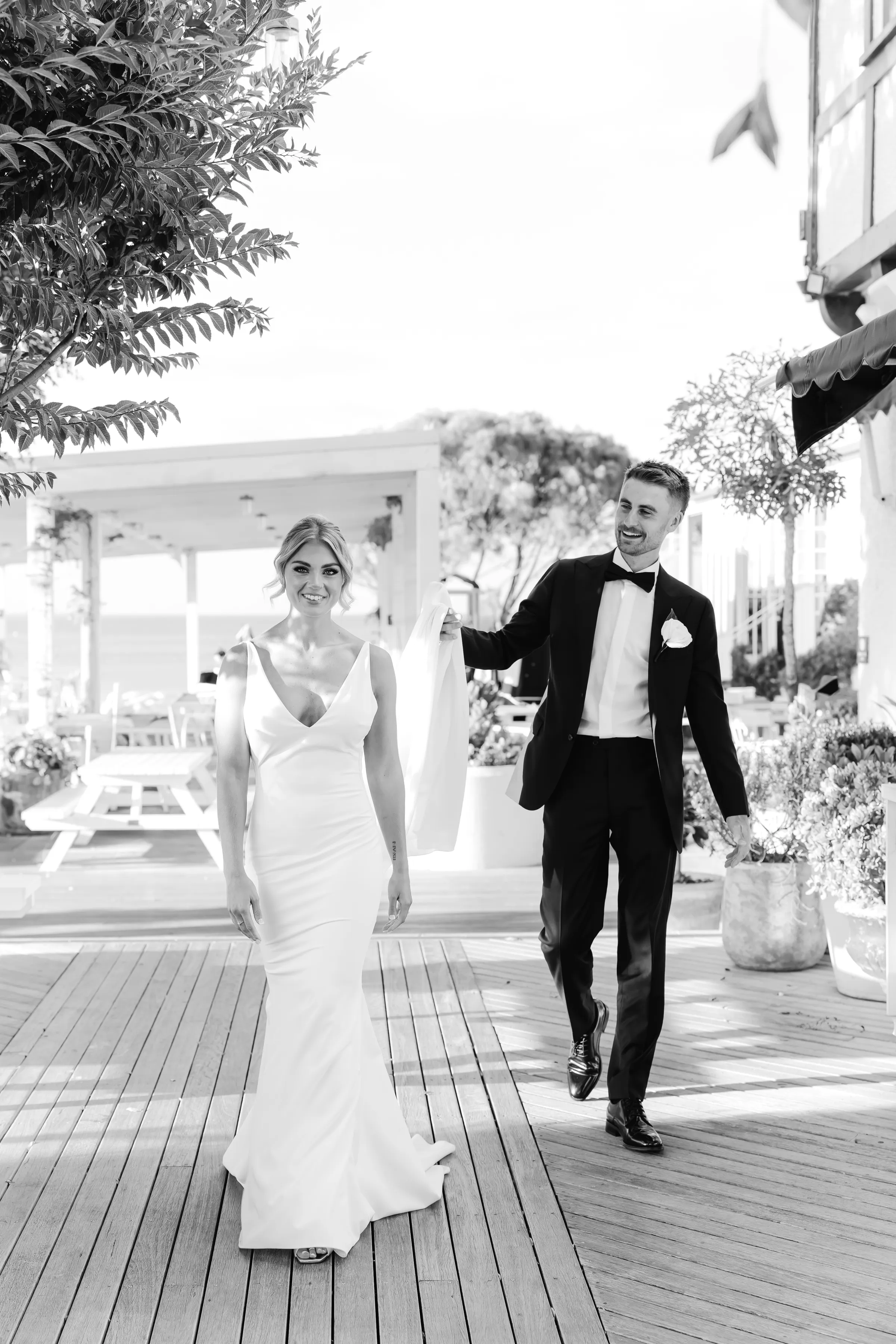 Couple walking along a pier in black and white