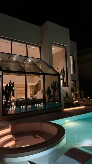 An illuminated terrace and swimming pool