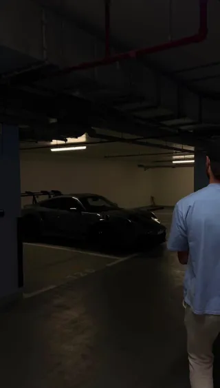 A candid moment in a garage beside a sports car