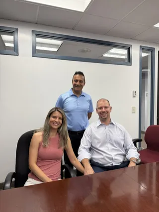 Three people sharing a moment in a meeting room.