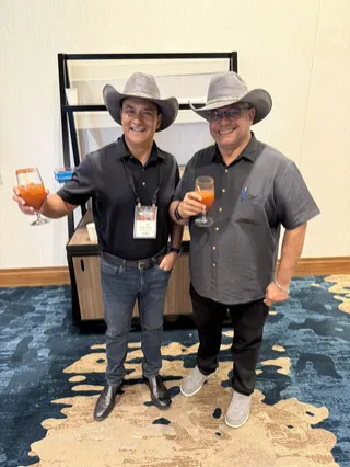 Two people in cowboy hats at a gathering.
