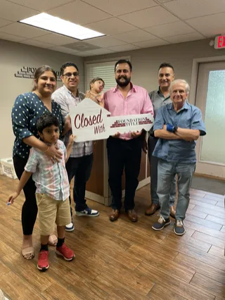 A family celebrating with a large Closed key.