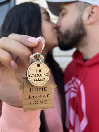 A couple celebrating with a key sign.