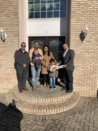 A group gathered outside a brick home.