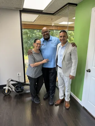 Three people smiling together in an office.