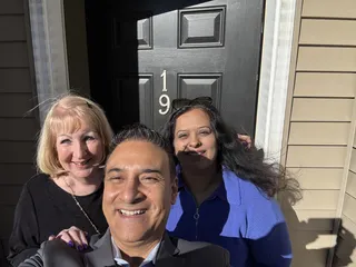 Three people taking a selfie near a front door.