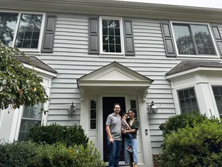 A family outside a gray home.
