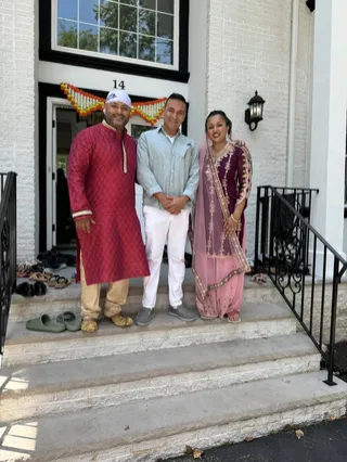 Three people gathered on a front porch.