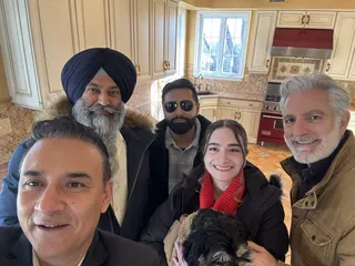 A group and a dog taking an indoor selfie.