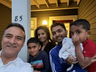 A family taking a selfie outside a home.