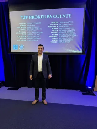 A portrait beside an industry event display.
