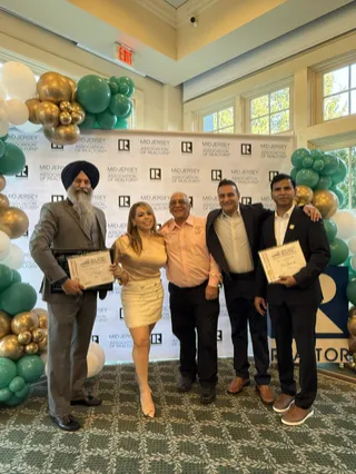 A group portrait with certificates at an event.