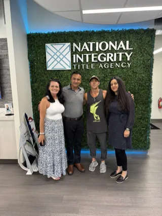 Four people gathered in a title office.
