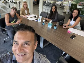 A group selfie around a meeting table.