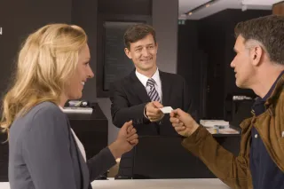 Hotel receptionist welcoming guests at the front desk