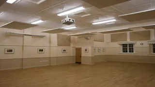 Suspended beige ceiling panels above the wooden floor at Messing Village Hall.