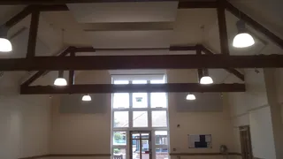 White ceiling panels between dark timber beams at the Christ Church Centre in Henley-on-Thames.