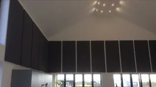 Tall dark acoustic panels above the windows in Wilsons Orchard farm kitchen.