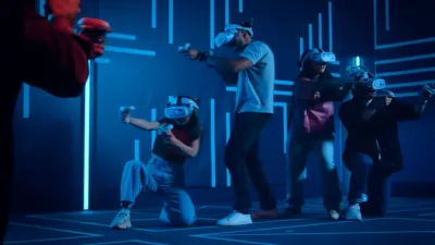 Players in VR headsets and vests aiming in the Another World VR arena