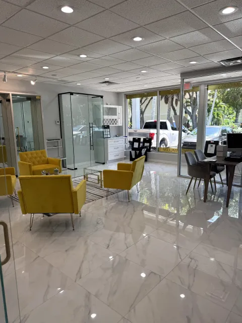 Bright showroom interior with yellow seating and glass enclosure displays