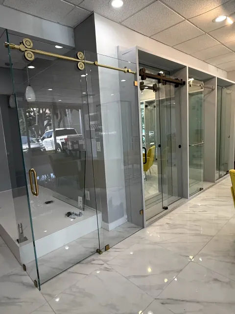 Close view of glass enclosure displays with brass-tone and black sliding door hardware