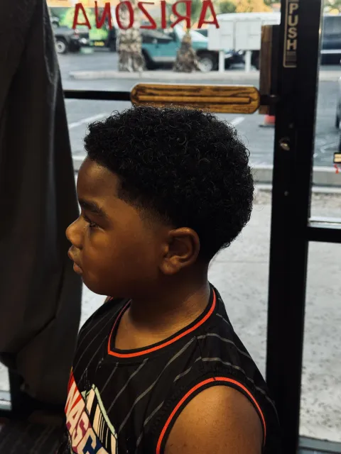 Kids haircut finished, side profile by the shop window