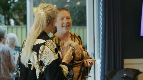 Two guests laughing by the terrace doors at an event at The Fig Tree, Shanklin