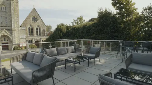 Outdoor terrace with sofas beside the church at The Fig Tree, Shanklin