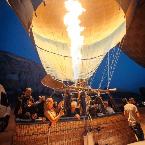 Guests in a balloon basket beneath the burner flame